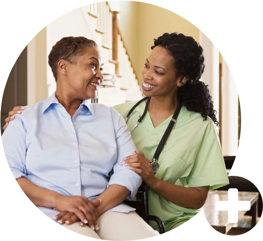 A nurse and an older woman smiling for the camera.